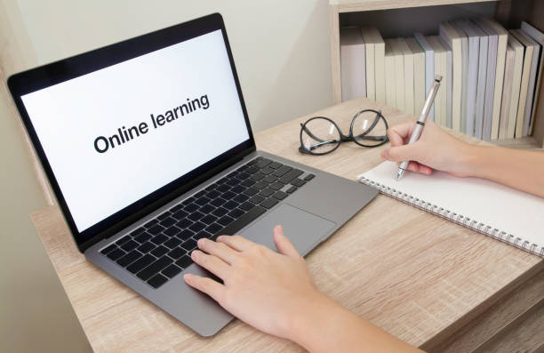 istock Online learning during coronavirus infection crisis. Cropped photo of hand taking note and using laptop. 1225748820