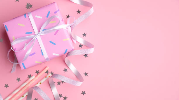 istock Flat lay composition with bright pink gift box, drink straws, silver ribbon and confetti. First baby birthday party celebration concept. 1225749058