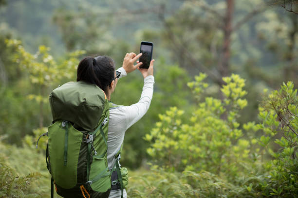 istock Woman hiker using smartphone taking pictures in spring mountain 1225750154