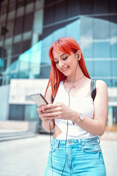 istock Female Setting Up Her Playlist On Smartphone While Walking Outside 1225751097