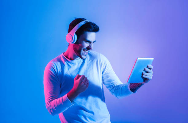 istock Guy rejoices in winning online game at tablet 1225752987