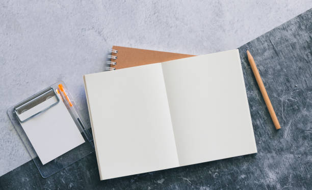istock Top view of white binder blank notebook or diary or journal for writing text and message with pencil on concrete background with copy space. Minimalism lifestyle of business and education concept. 1225753692