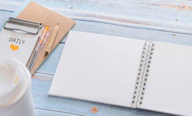 istock White binder blank notebook or diary or journal for writing text and message with pencil and coffee cup on blue pastel wood background with copy space. Still lifestyle photo concept. 1225753924