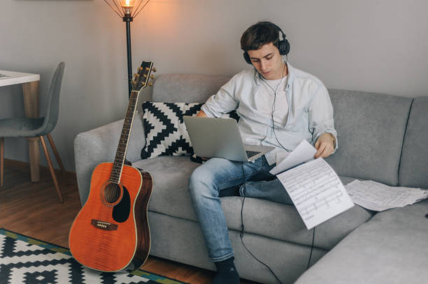 istock Young man playing guitar for his YouTube channel 1225754831