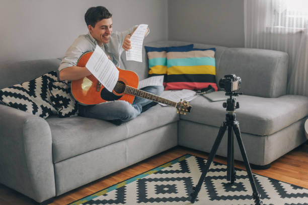 istock Young man playing guitar for his YouTube channel 1225754859