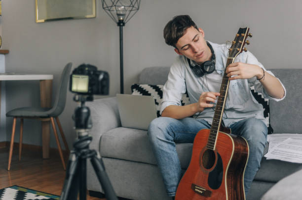 istock Young man playing guitar for his YouTube channel 1225754903
