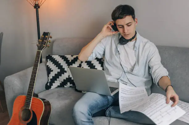 Photo of Young man playing guitar for his YouTube channel