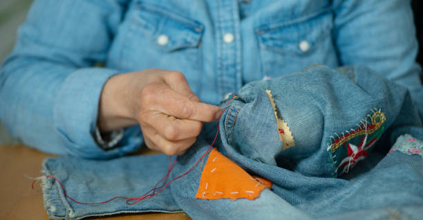 istock elderly woman hands sewing on a fabric jeans 1225756553