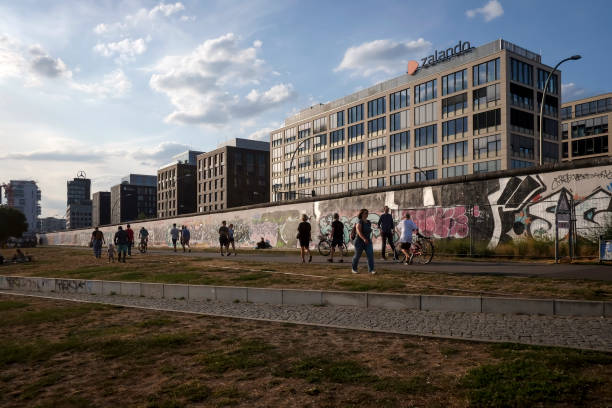 muro de berlín - graffiti paintings men walking fotografías e imágenes de stock