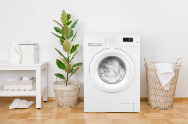 istock Laundry room interior with washing machine, basket and white wall 1225758211