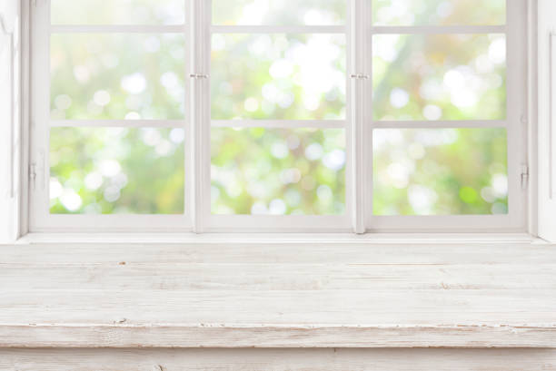 istock Vintage wooden table on blurred window background for product display 1225758298
