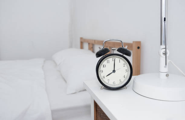 horloge sur la table d’appoint dans la chambre à coucher, l’intérieur et le concept de soins de santé. - clock nobody decoration minute hand photos et images de collection