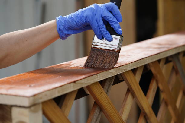 istock worker paints wooden furniture with protective paint 1225762840