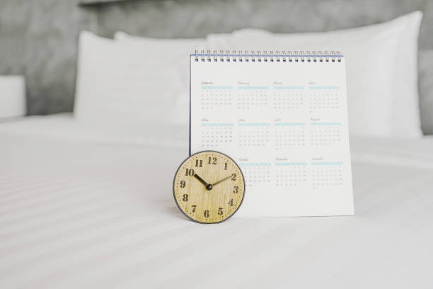 istock analog clock and calendar on white bed in bedroom 1225763118