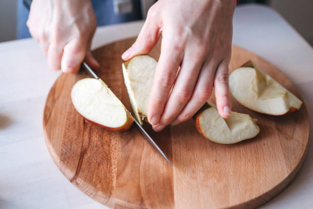 Woman cuts apple. stock photo