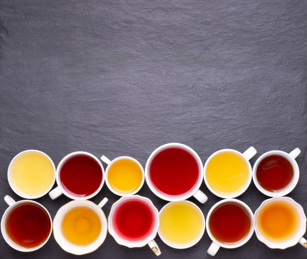 istock Assortment of tea cups on dark, stone background, top view 1225765633