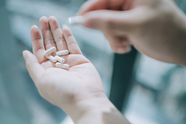 istock close up on human hand taking medicine pill supplement vitamin 1225766383
