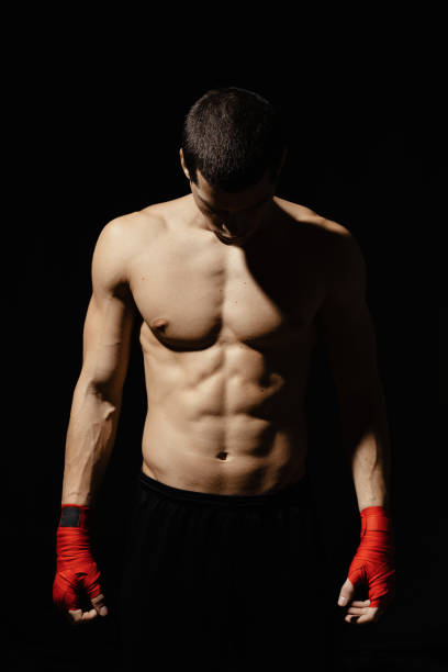 istock Athletic boxer getting ready before the fight over black background 1225766558