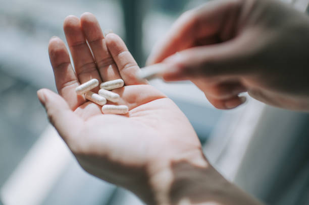 istock close up on human hand taking medicine pill supplement vitamin 1225766585