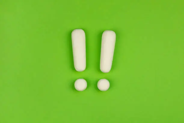 Photo of Two exclamation marks on green background. Keep attention concept, warning. Important information.