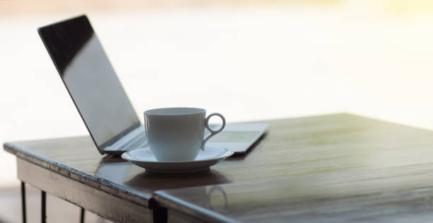 istock A cup of coffee and a laptop with morning sunlight. 1225767998