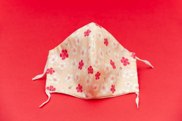 istock Floral pattern (red, white and salmon color) DIY fabric face mask for protection against coronavirus (COVID-19) and other infectious diseases. Close-up. 1225770834