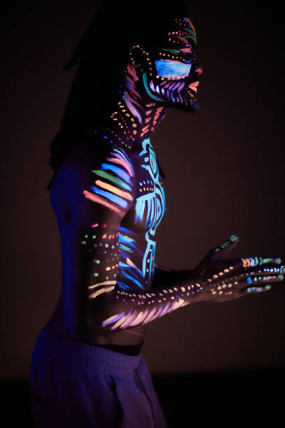 istock man in UV paint isolated, dark background 1225771083