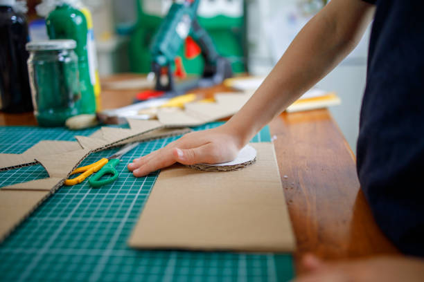 istock Smiling boy making a cardboard dinosaur costume 1225772672