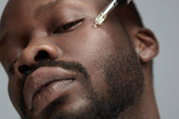 Male Skin Care. Face Beauty Procedure For African Model. Oil Vitamins Treatment For Facial Restore And Renewal. Cometic Product For Facecare. stock photo