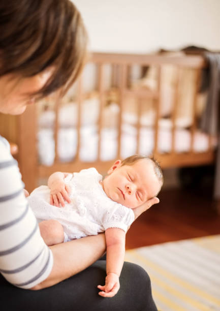 istock Baby sleeping in her mother's arms 1225774643