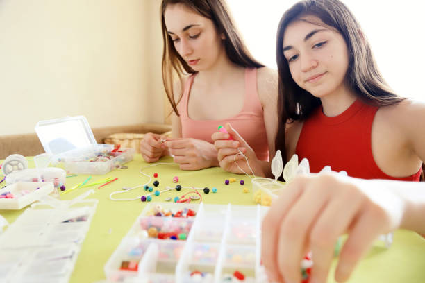 istock Young girls making bead bracelets 1225775147