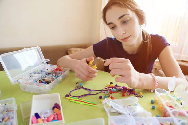 istock Young woman making bead bracelets 1225775149