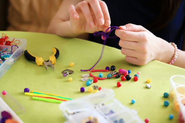 istock Close-up of female hands making bead bracelets 1225775150