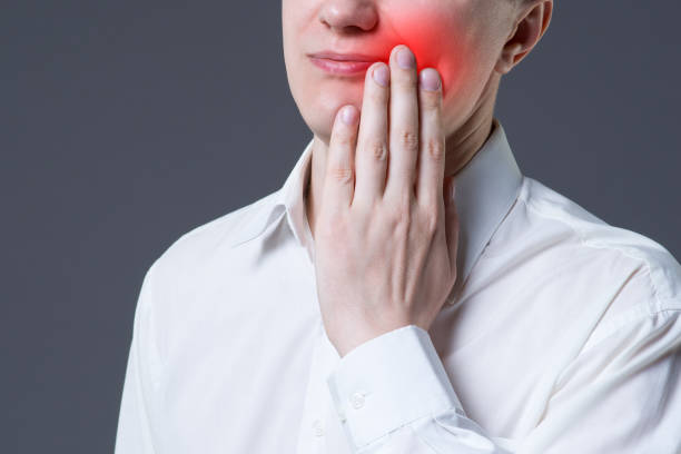 istock Man suffering from a toothache on gray background 1225775854