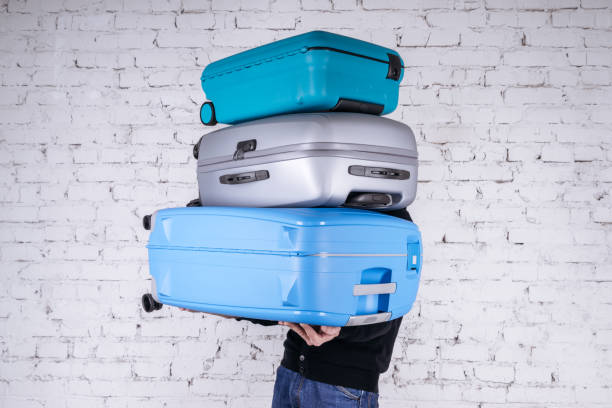 istock Man holding three heavy suitcases in hand 1225779693