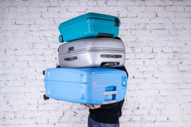 istock Man holding three heavy suitcases in hand 1225779728
