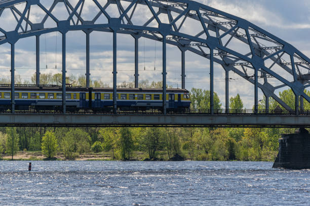 istock An electric train rides on a bridge crossing a river. Passenger train on the railway bridge. 1225779938