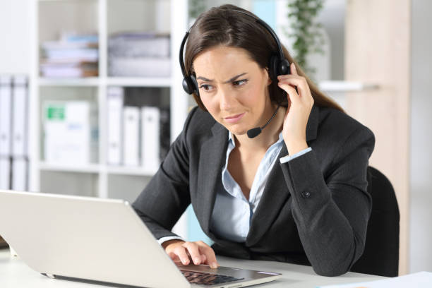 istock Suspicious telemarketer looking at laptop in the office 1225780624