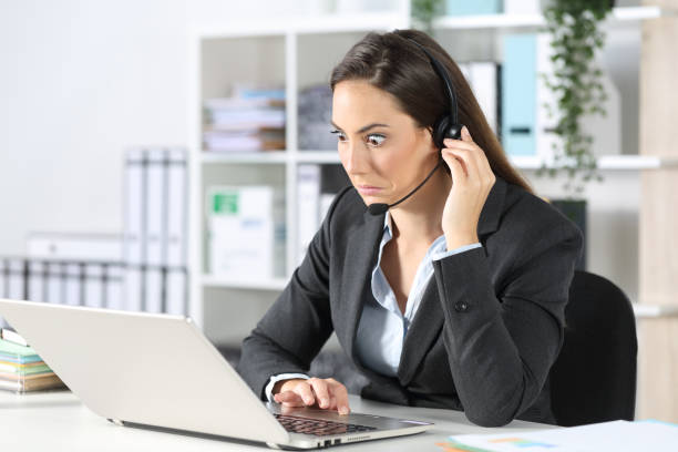 Confused telemarketer looking at laptop at office Confused telemarketer looking at laptop at office sad disbelief stock pictures, royalty-free photos & images
