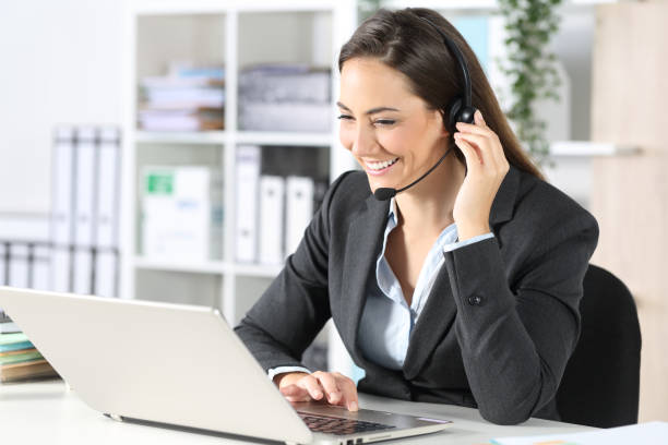 istock Happy telemarketer with laptop attending call at office 1225780838