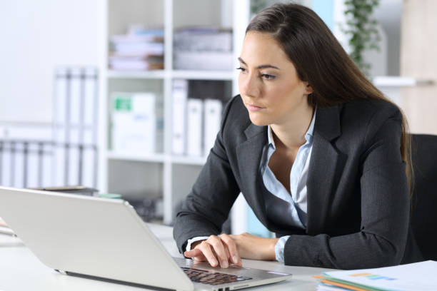 istock Distracted executive with laptop looking away at office 1225780906