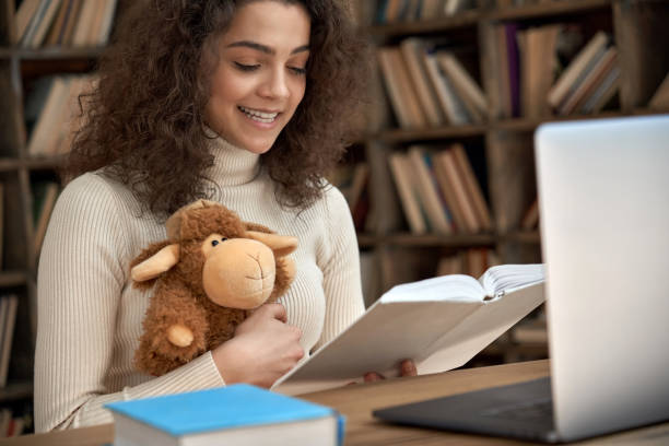 Hispanic woman remote kids teacher reading fairy tale book teaching online. Young happy latin girl holding book and toy looking at laptop computer webcam. Distance children video call zoom education. mujer hispana niños remotos maestro leyendo libro de cuentos de hadas enseñando en línea. joven chica latina feliz sosteniendo libro y juguete mirando la cámara web de la computadora portátil. educación de zoom de videollamadas a distancia para niño