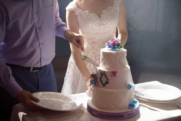 istock Wedding cake. A bride and a groom is cutting their wedding cake 1225783907