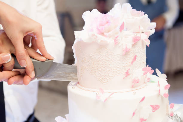 istock Wedding cake. A bride and a groom is cutting their wedding cake 1225783964