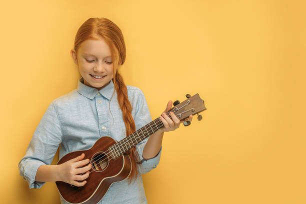 beautiful girl play ukulele isolated