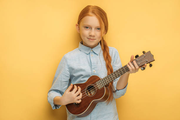 istock awesome child girl play ukulele 1225784481