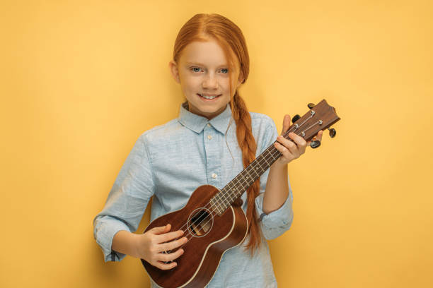 istock adorable girl learns to play ukulele 1225784539