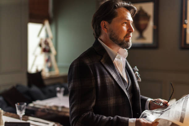 istock Well-dressed business man reading newspaper in indoor restaurant 1225786084