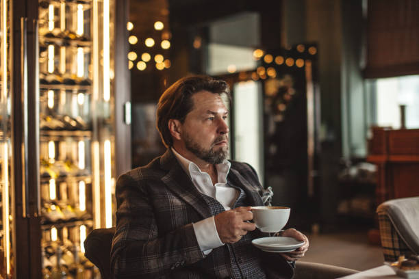 istock Thoughtful mid-aged businessman drinking coffee and looking away in restaurant 1225786111