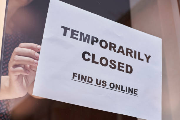 istock Shop or restaurant worker hanging closed sign 1225786282
